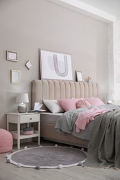 Photo of Bed with stylish linens near grey wall in room