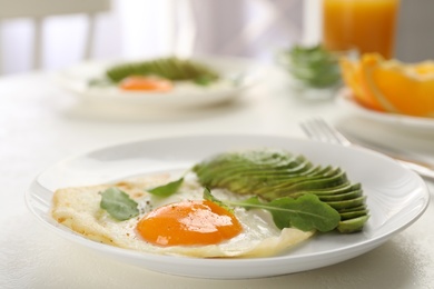 Photo of Tasty breakfast with fried egg and avocado on light table