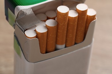 Photo of Cigarettes with orange filters in pack, closeup