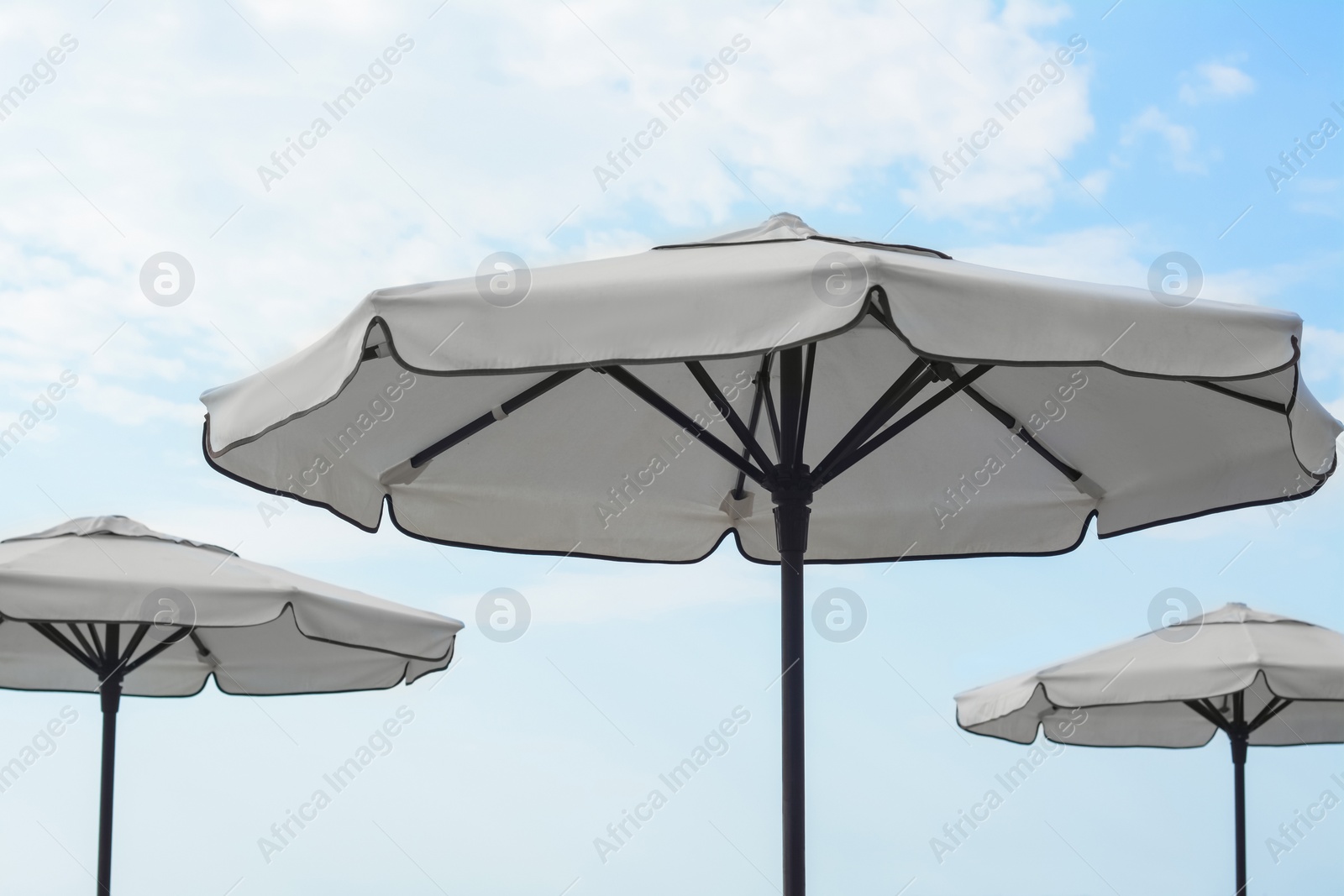 Photo of Beautiful white beach umbrellas against blue sky