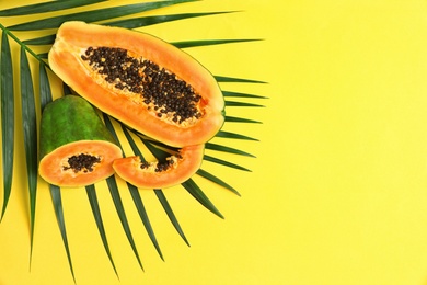 Photo of Flat lay composition with cut papaya on yellow background, space for text