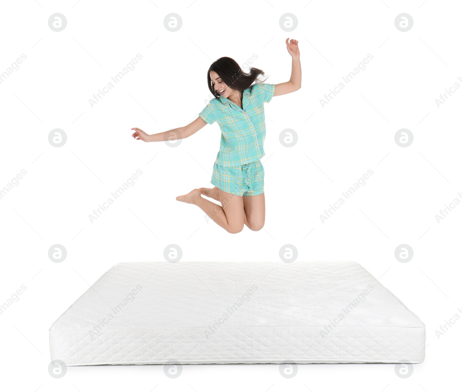 Photo of Young woman jumping on mattress against white background