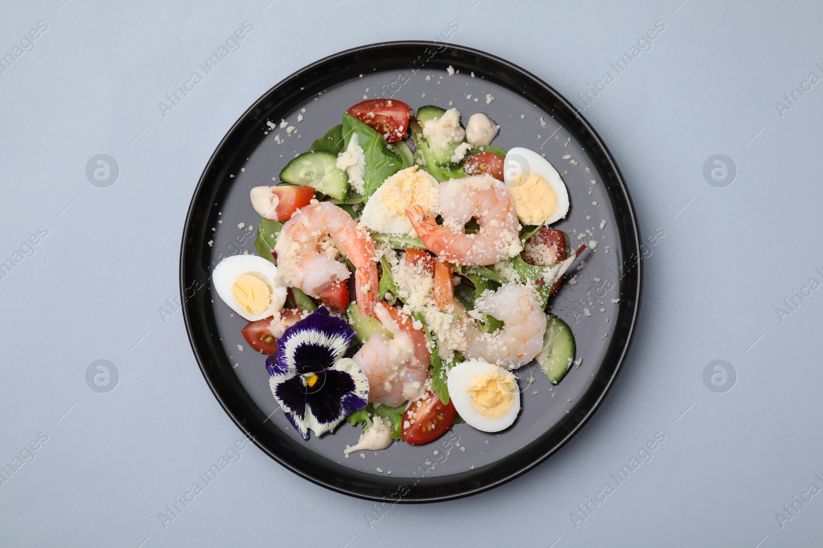Photo of Delicious Caesar salad with shrimps on grey background, top view