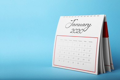 Photo of Paper calendar on light blue background, space for text. Planning concept