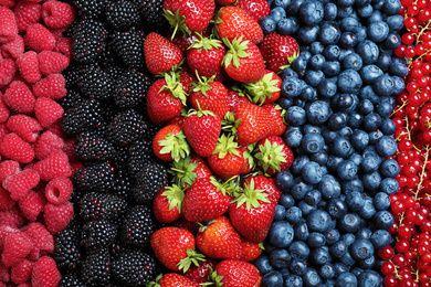 Photo of Mix of different ripe tasty berries as background, top view