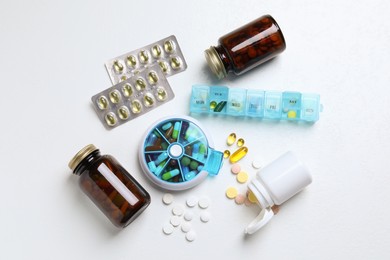 Photo of Pill boxes with medicaments on white table, flat lay