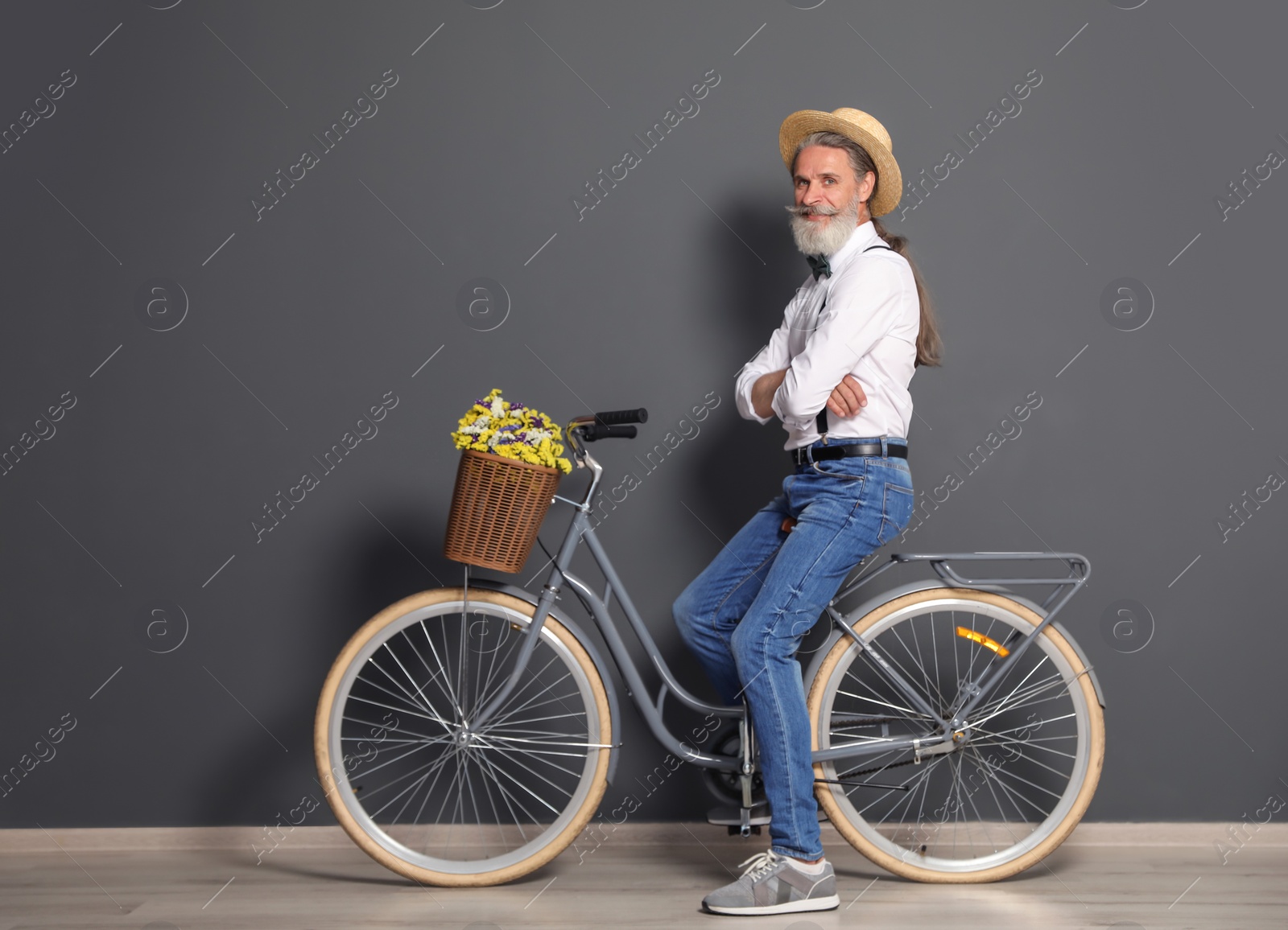 Photo of Portrait of handsome mature man with bicycle near color wall