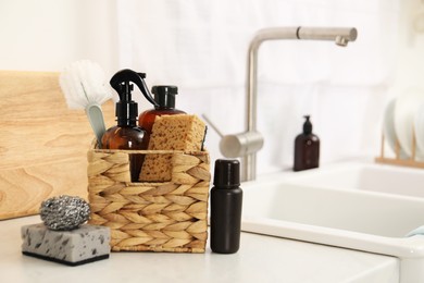 Different cleaning supplies in basket on countertop. Space for text