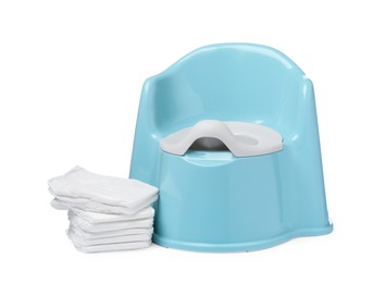 Photo of Light blue baby potty and stack of diapers isolated on white. Toilet training