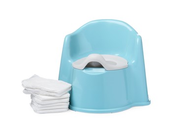 Light blue baby potty and stack of diapers isolated on white. Toilet training