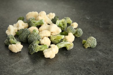 Frozen broccoli and cauliflower on gray table, closeup