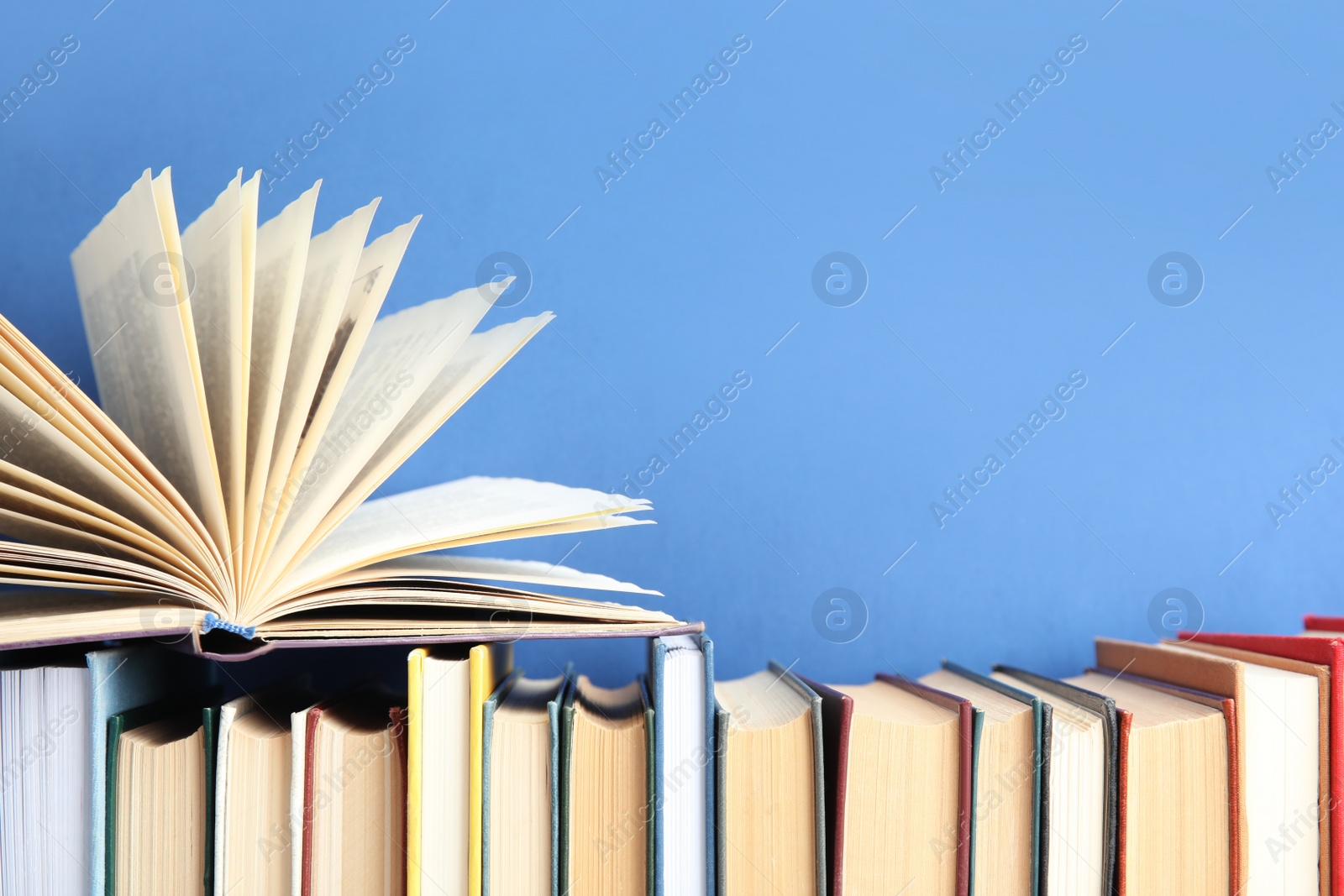 Photo of Collection of old books on blue background. Space for text
