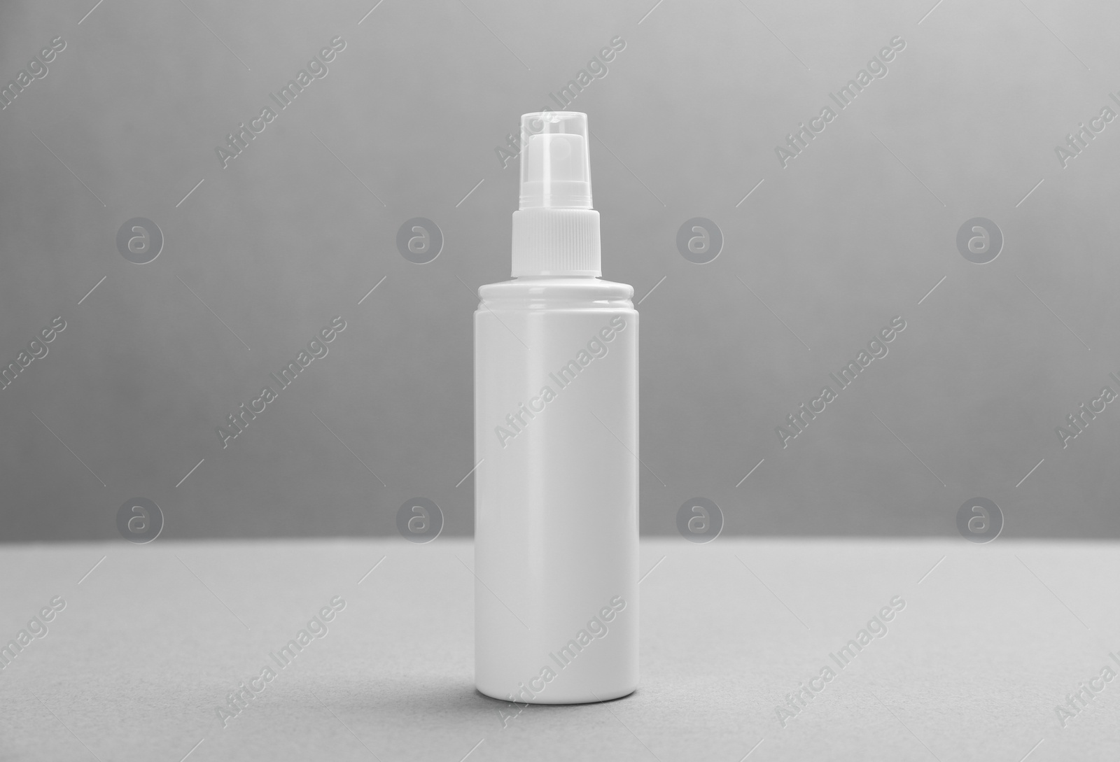 Photo of Bottle with insect repellent spray on grey background