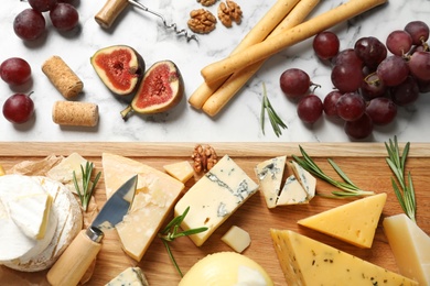 Flat lay composition with different types of delicious cheese on marble table