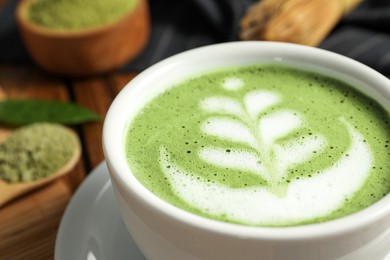 Photo of Delicious matcha latte in cup on table, closeup