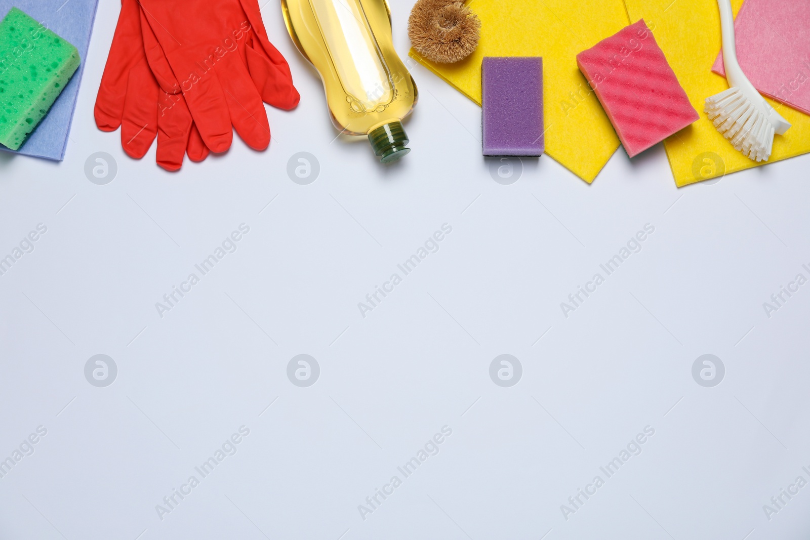 Photo of Flat lay composition with sponges and other cleaning products on white background. Space for text