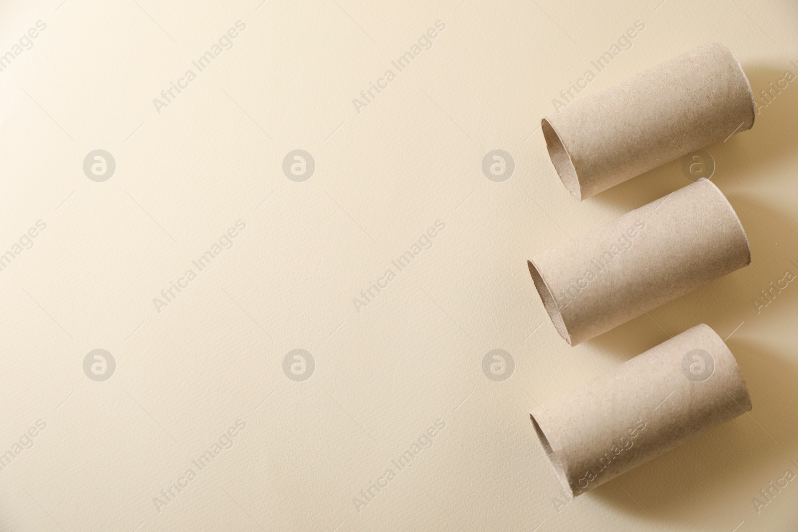 Photo of Empty toilet paper rolls on beige background flat lay. Space for text