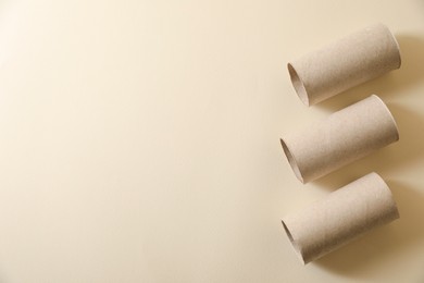 Photo of Empty toilet paper rolls on beige background flat lay. Space for text