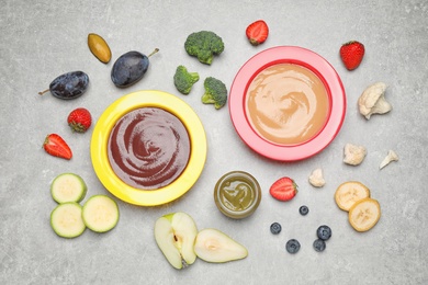 Healthy baby food and ingredients on grey table, flat lay