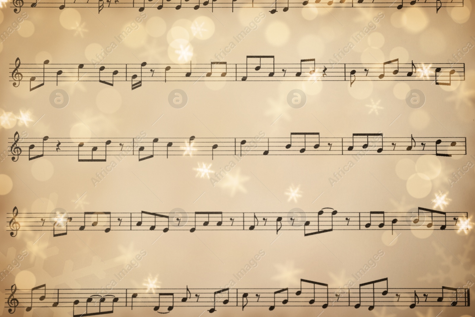 Image of Top view of old sheet with Christmas music notes as background, snowflakes and bokeh effect