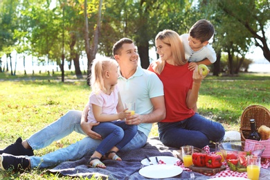 Happy family having picnic in park on sunny day