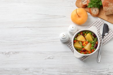 Photo of Bowl of delicious turnip soup served on white wooden table, flat lay. Space for text