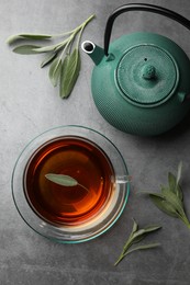 Aromatic herbal tea with sage on grey table, flat lay