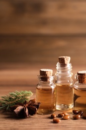 Photo of Anise essential oil and spice on wooden table