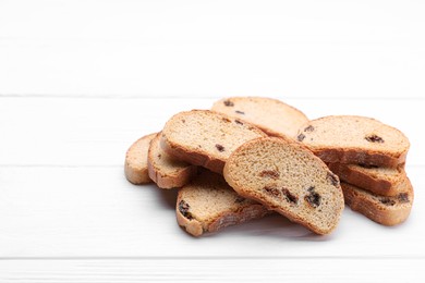 Photo of Sweet hard chuck crackers with raisins on white wooden table. Space for text