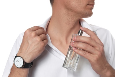 Handsome man applying perfume on neck against white background, closeup
