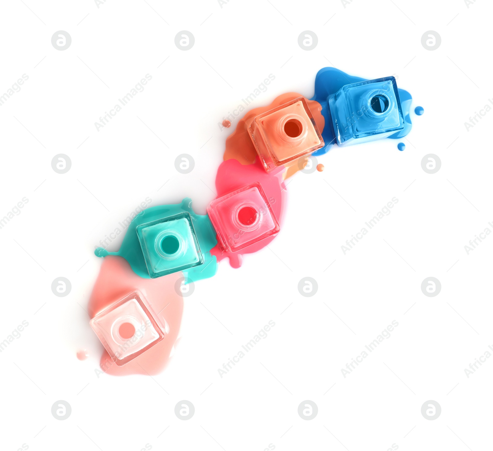 Photo of Spilled different nail polishes with bottles on white background, top view