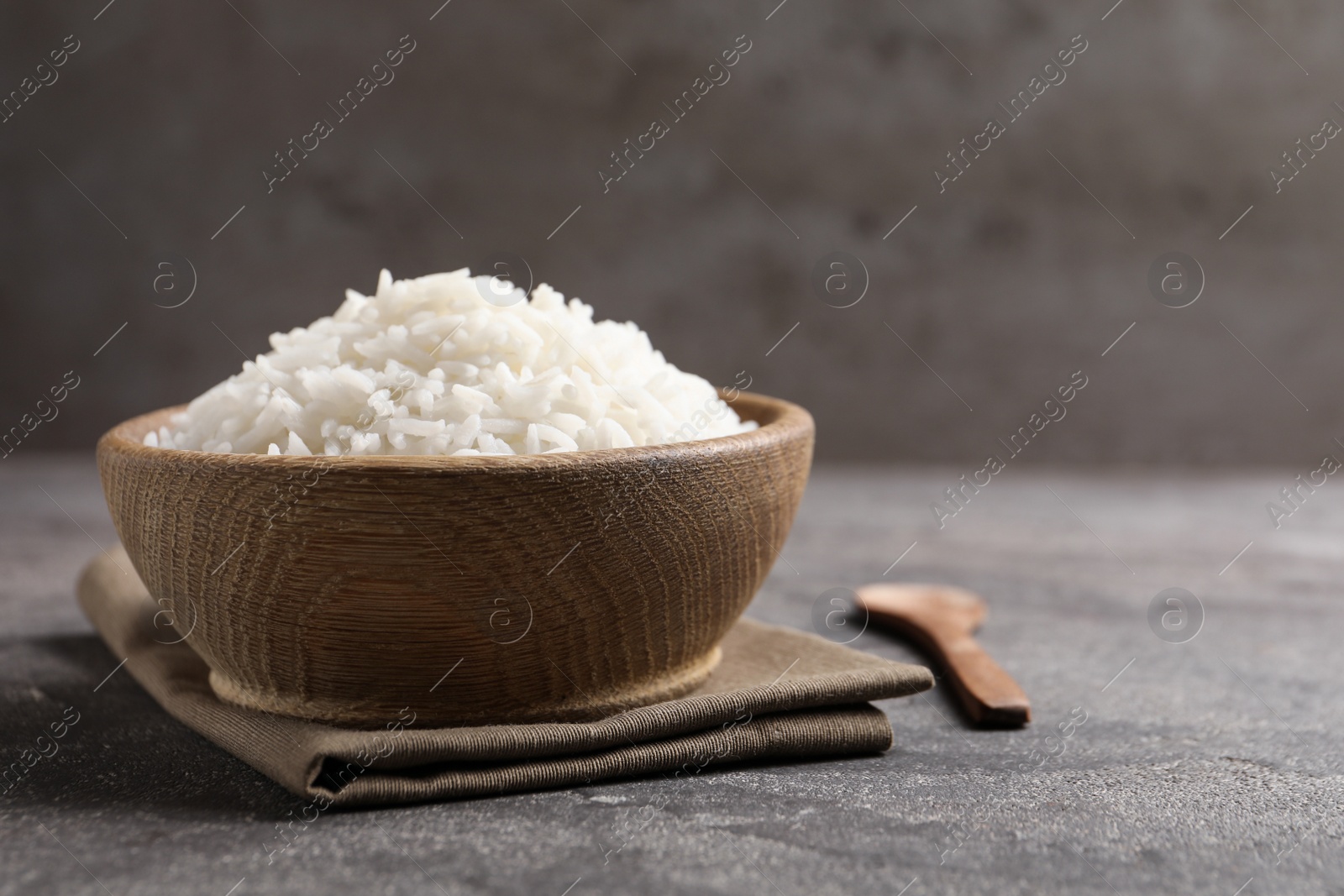 Photo of Bowl of tasty cooked rice served on table. Space for text