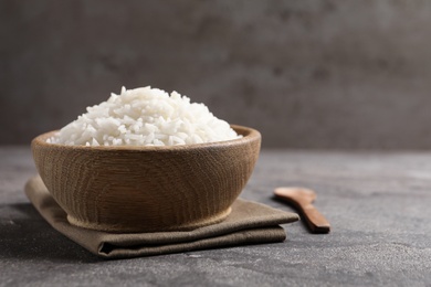 Bowl of tasty cooked rice served on table. Space for text