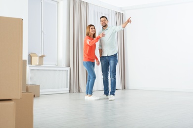 Happy couple and moving boxes in their new house