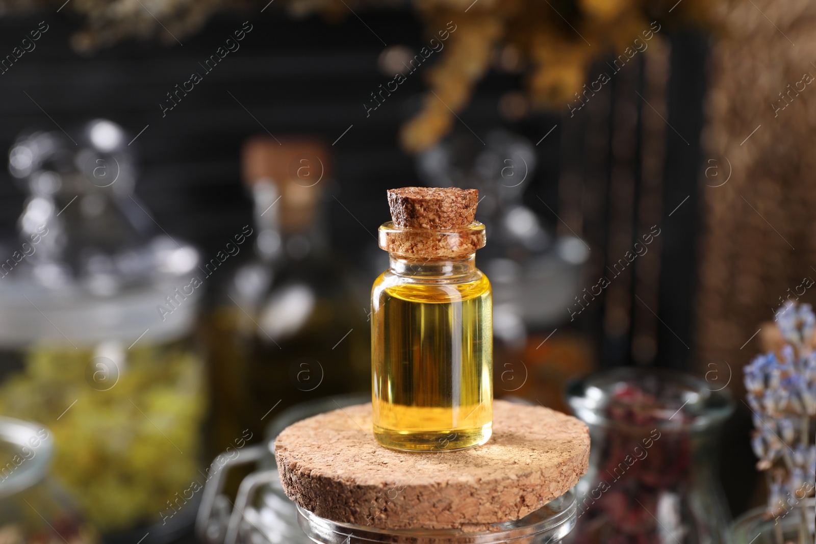 Photo of Bottle with herbal essential oils on blurred background. Space for text