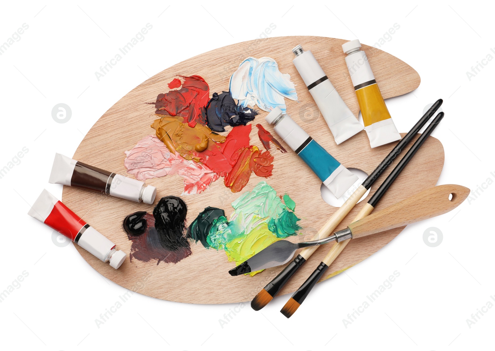 Photo of Wooden palette with oil paints and tools on white background, top view