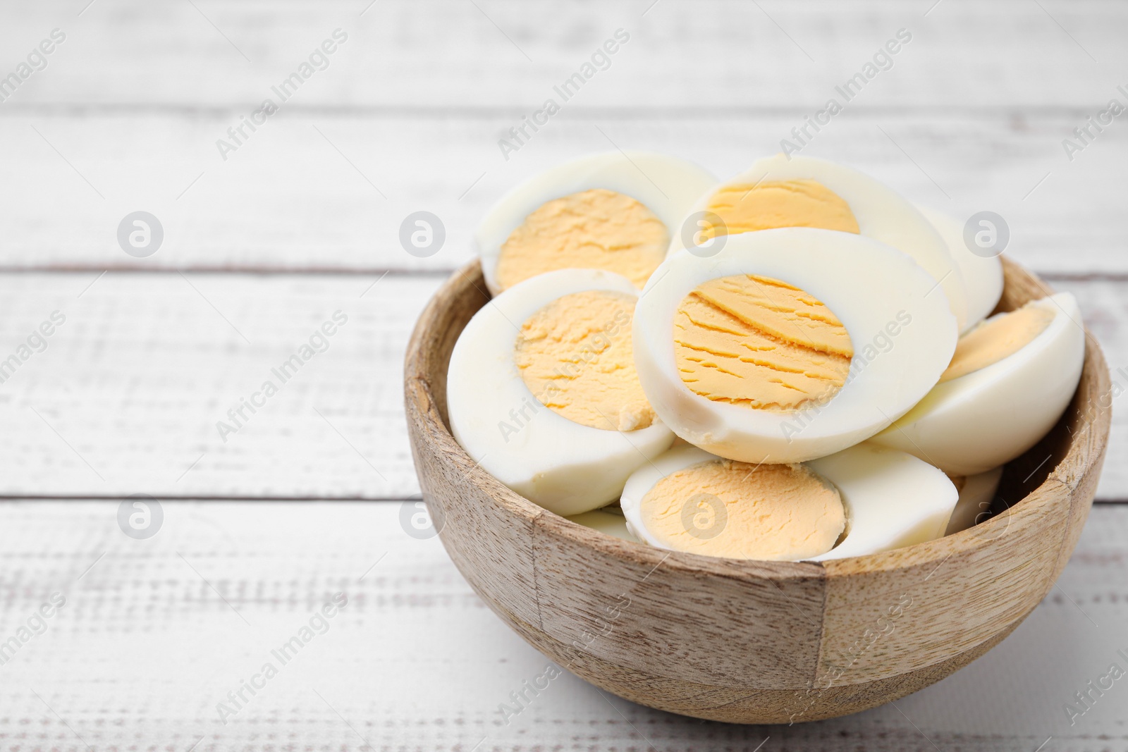 Photo of Bowl of fresh hard boiled eggs on white wooden table. Space for text