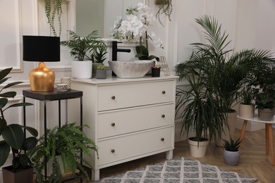 Photo of Stylish bathroom interior with modern furniture and beautiful houseplants