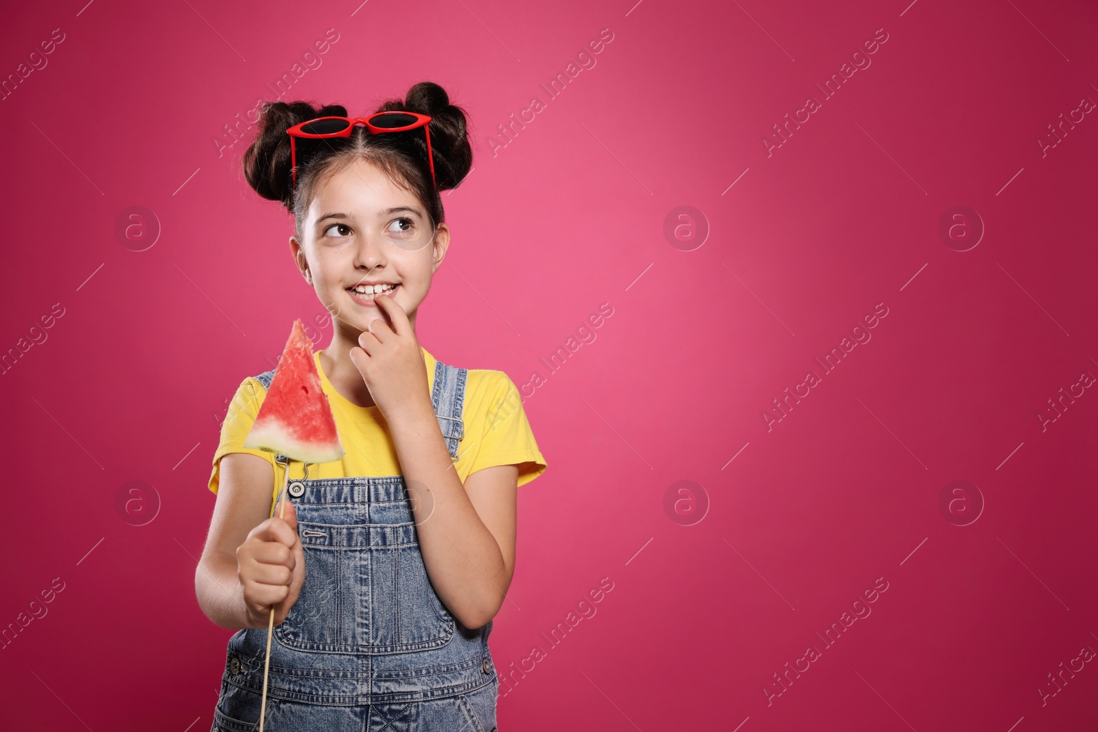 Photo of Cute little girl with watermelon on pink background. Space for text