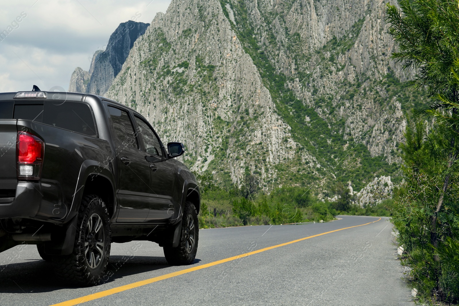 Photo of Black car on road near beautiful mountains outdoors