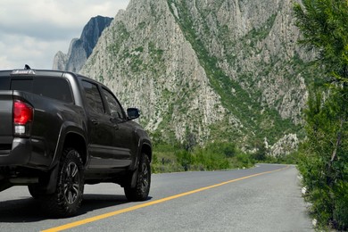 Photo of Black car on road near beautiful mountains outdoors