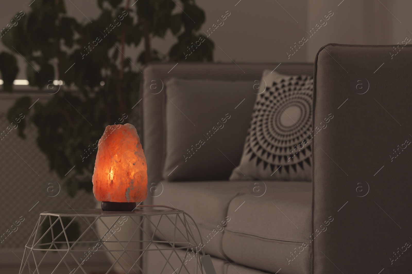 Photo of Exotic Himalayan salt lamp on table indoors