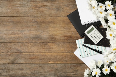 Set of stationery and flowers on wooden table, flat lay with space for text. Teacher's Day