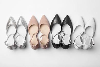 Photo of Many stylish female shoes on white background, top view