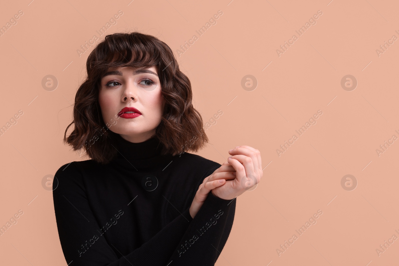 Photo of Portrait of beautiful young woman with wavy hairstyle on beige background. Space for text