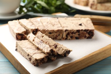 Photo of Pieces of tasty chocolate halva on table, closeup