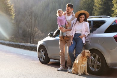 Photo of Parents, their daughter and dog near car outdoors, space for text. Family traveling with pet