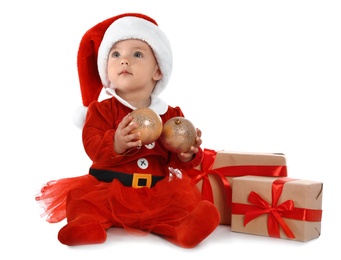 Photo of Festively dressed baby with gift boxes on white background. Christmas celebration