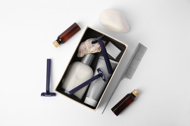Different men's shaving accessories and box on white background, flat lay