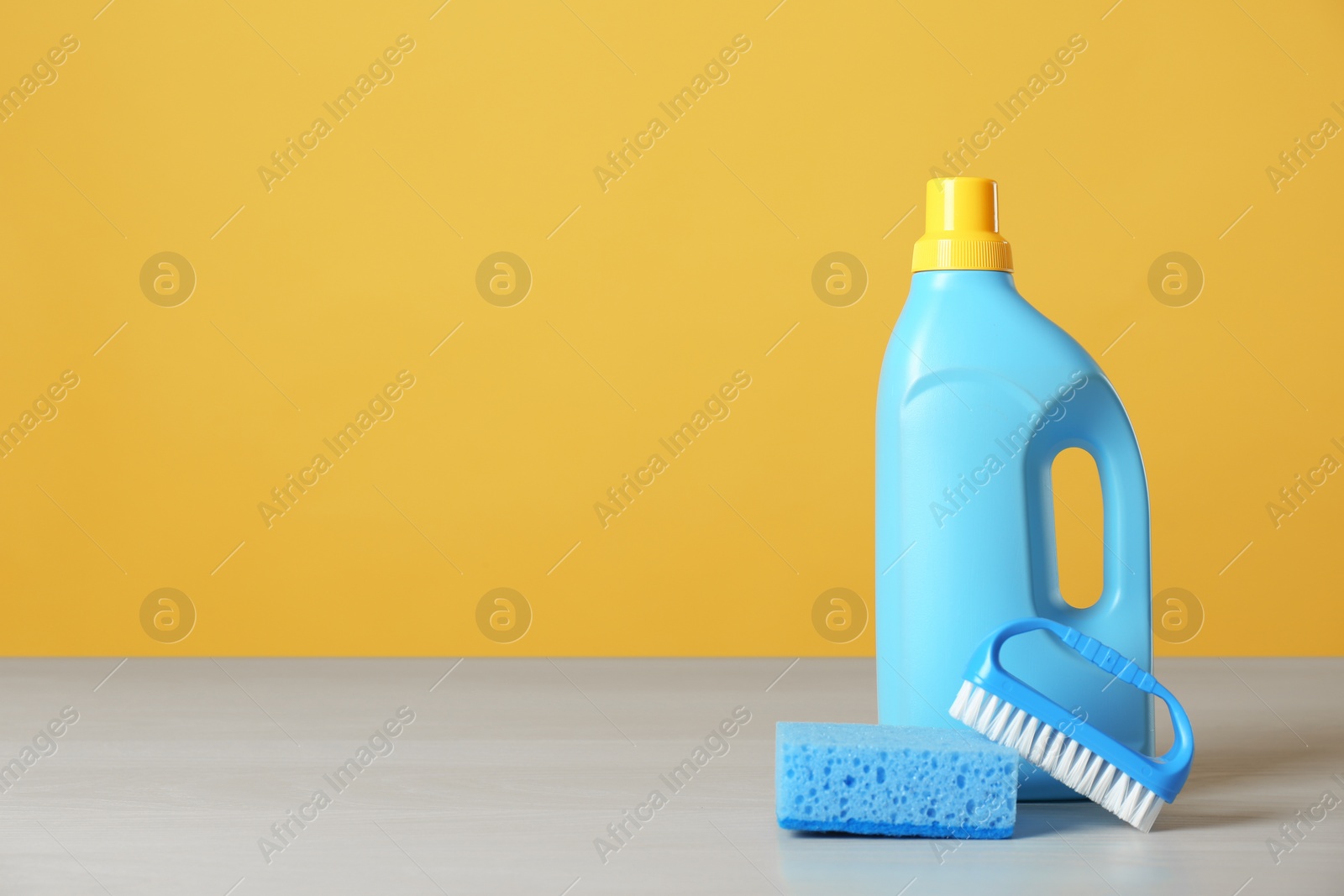 Photo of Bottle of cleaning product and supplies on light table. Space for text